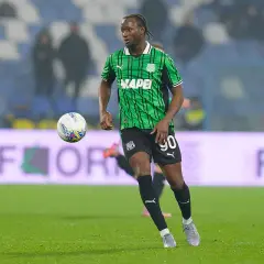 Piłkarz Sassuolo w zielono-czarnej koszulce z numerem 90 biegnie z piłką.