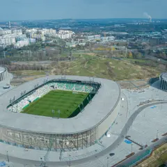 Nowoczesny stadion w Sosnowcu, ArcelorMittal Park, z zieloną murawą i trybunami. Jego pojemność pozwala na przyjęcie wielu kibiców.