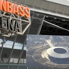 Zbliżenie na napis "DONBAS ARENA" nad nowoczesnym stadionem widzianym z lotu ptaka.