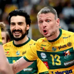 Dwóch uśmiechniętych siatkarzy, byli piłkarze reprezentacji Polski, w żółtych koszulkach z numerem 13.