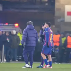 Pedri, w koszulce z numerem 8, opuszcza boisko z powodu kontuzji. W tle widać karetkę i czerwony krzyż.
