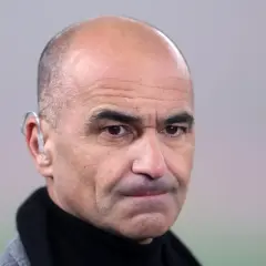 Martinez, trener z charakterystycznym aparatem słuchowym, patrzy wprost.