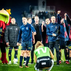 Piłkarze ze Szczecina świętują zwycięstwo. Na murawie widać też maskotkę klubu i fotoreportera.