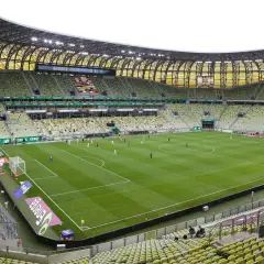 Stadion Lechii Gdańsk, z zielonymi trybunami i murawą, gotowy na mecz. Jego pojemność robi wrażenie.