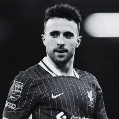 Diogo Jota, piłkarz Liverpoolu, w czarno-białym ujęciu. Skupiony wzrok, charakterystyczna fryzura.