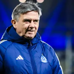 Doświadczony trener Ruchu Chorzów w niebieskiej kurtce z herbem klubu.