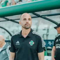 Trener Radomiaka w czarnej koszulce z herbem klubu, skupiony na boisku.