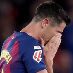 Piłkarz Robert Lewandowski z twarzą ukrytą w dłoniach, smutny po przegranym meczu, być może symbolizującym koniec kariery.