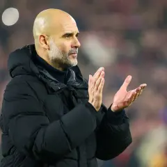 Pep Guardiola, uznawany za najlepszego trenera na świecie, klaszcze na tle trybun.