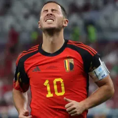 Hazard, belgijski piłkarz, z grymasem na twarzy, w czerwonej koszulce z numerem 10.