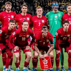 Reprezentacja Polski w piłce nożnej, znana jako polska FIFA, pozuje do zdjęcia w czerwonych strojach.