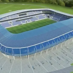 Nowoczesny stadion Wisły Płock z niebieskim dachem i trybunami. Obiekt ma imponującą pojemność, gotowy na przyjęcie kibiców.