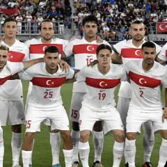 Piłkarze reprezentacji **turcja fc** w białych strojach z czerwonym pasem i godłem. Bramkarz w żółtym.