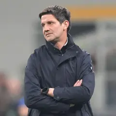 Trener Interu, Simone Inzaghi, w ciemnej kurtce, z rękami skrzyżowanymi na piersi, patrzy w bok.