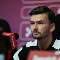 Trener Górnika Zabrze, w czarno-białej koszulce, siedzi przy mikrofonie Superbet.