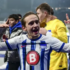 Radość zawodników Herthy BSC po zwycięstwie w 2. Bundeslidze. Młody piłkarz z uniesionymi rękami świętuje sukces.