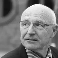 Portret starszego mężczyzny w okularach, który wygląda jak doświadczony lenczyk trener piłkarski, zamyślony.
