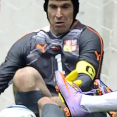 Petr Čech w kasku po groźnej kontuzji głowy, w akcji ratuje bramkę.