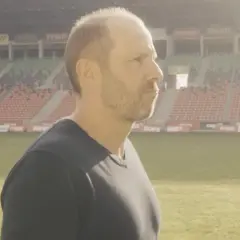 GKS Tychy trener wpatruje się w pusty stadion, gotowy na kolejne wyzwania.