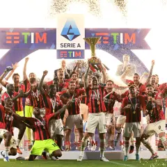 Piłkarze świętują zdobycie scudetto, unosząc puchar Serie A wśród konfetti i fajerwerków.