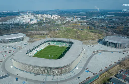 Nowoczesny stadion w Sosnowcu, ArcelorMittal Park, z zieloną murawą i trybunami. Jego pojemność pozwala na przyjęcie wielu kibiców.