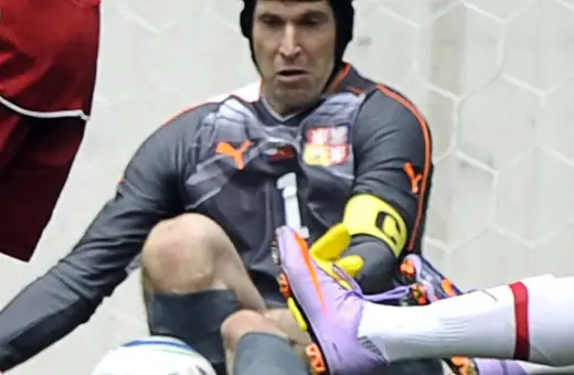Petr Čech w kasku po groźnej kontuzji głowy, w akcji ratuje bramkę.