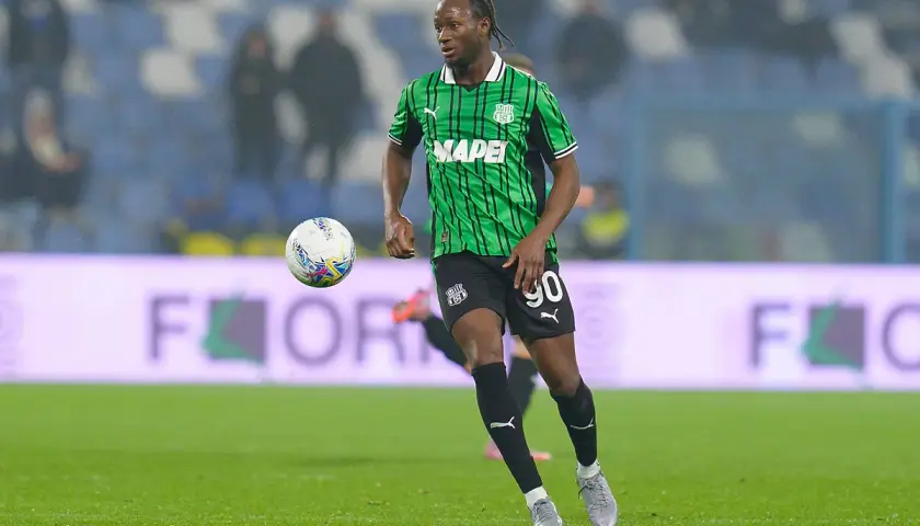 Piłkarz Sassuolo w zielono-czarnej koszulce z numerem 90 biegnie z piłką.