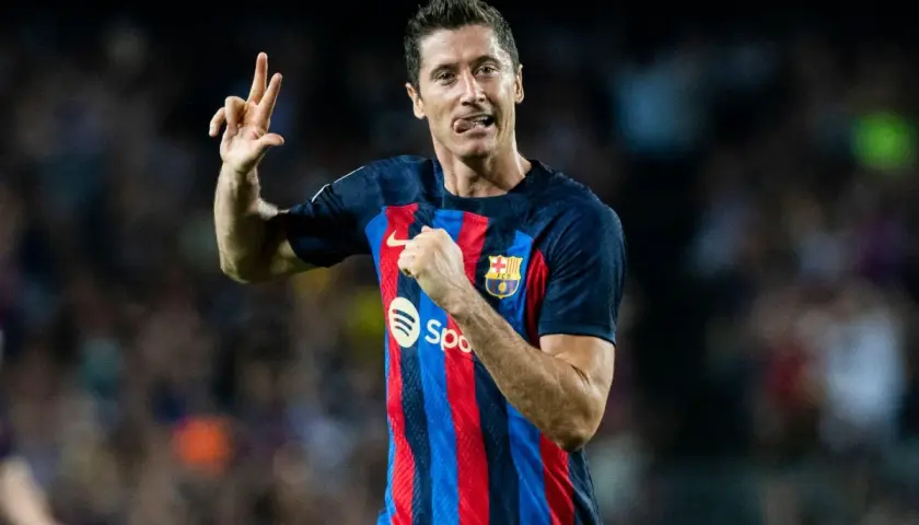 Piłkarz FC Barcelona, Robert Lewandowski, świętuje hat trick, pokazując trzy palce.
