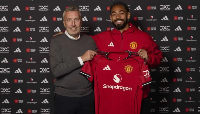 Dwóch mężczyzn prezentuje czerwoną koszulkę Manchester United. To kolejny z ekscytujących manchester united transfery.