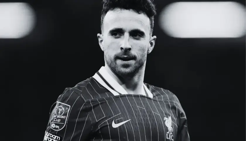 Diogo Jota, piłkarz Liverpoolu, w czarno-białym ujęciu. Skupiony wzrok, charakterystyczna fryzura.