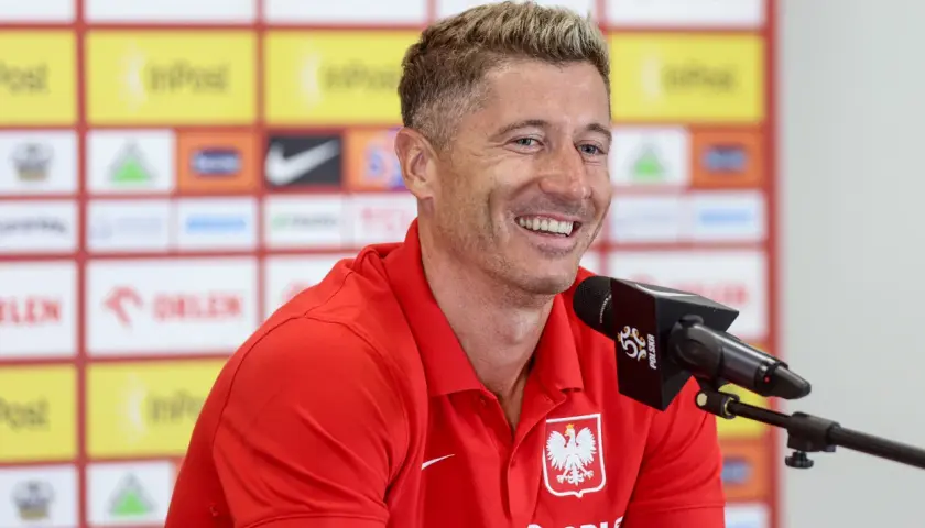 Uśmiechnięty Robert Lewandowski w czerwonej koszulce z orłem. Ciekawe, ile języków zna Robert Lewandowski, by dogadać się z fanami z całego świata.