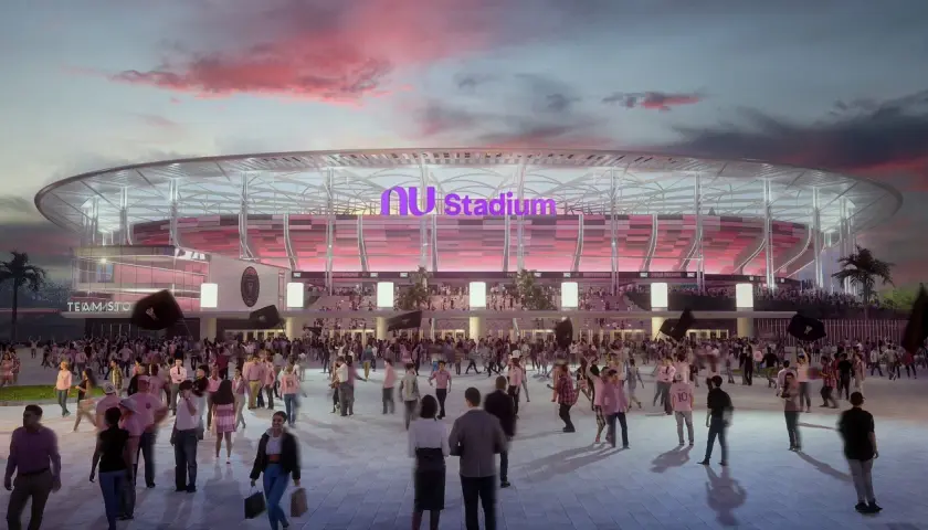 Tłum kibiców zmierza na mecz do Inter Miami Stadium. Zachodzące słońce maluje niebo na różowo, a stadion lśni w różowych barwach.