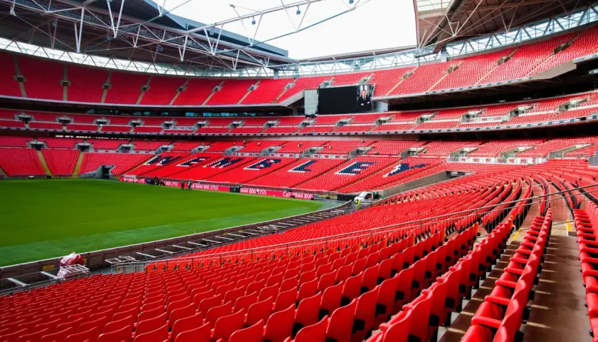 Puste czerwone trybuny jednego z największych stadionów w Anglii, Wembley, czekają na kibiców.