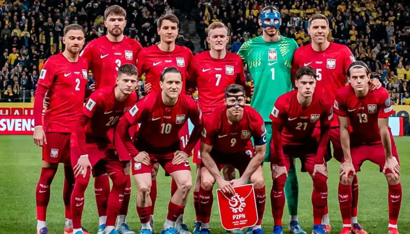 Reprezentacja Polski w piłce nożnej, znana jako polska FIFA, pozuje do zdjęcia w czerwonych strojach.