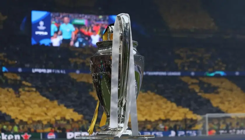 Trofeum Ligi Mistrzów na tle trybun. Kto wygrał ligę mistrzów? To pytanie zadają sobie kibice, patrząc na ten symbol zwycięstwa.