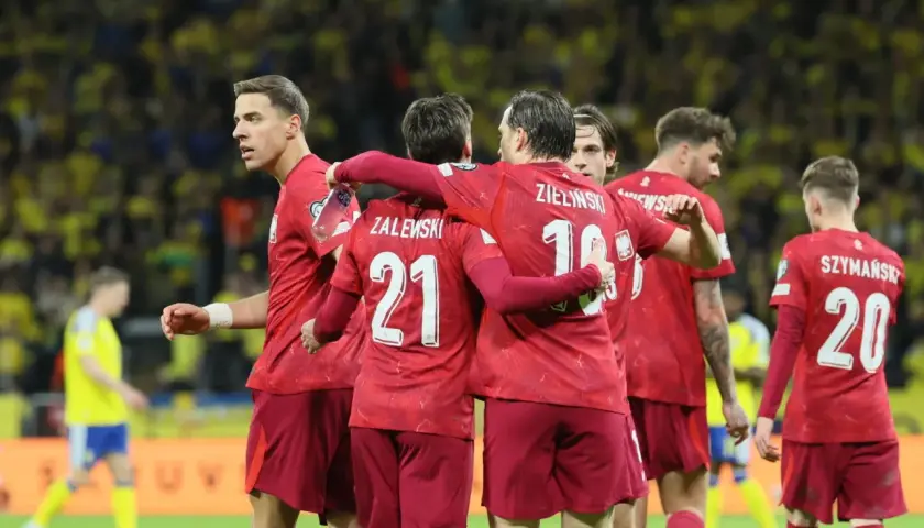 Piłkarze w czerwonych koszulkach świętują, czy polska jedzie na mundial? Zwycięstwo na boisku.