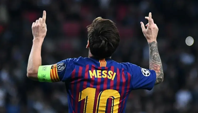 Leo Messi z podniesionymi rękami, w koszulce FC Barcelona z numerem 10. Symbol jego wielkiej historii w klubie.