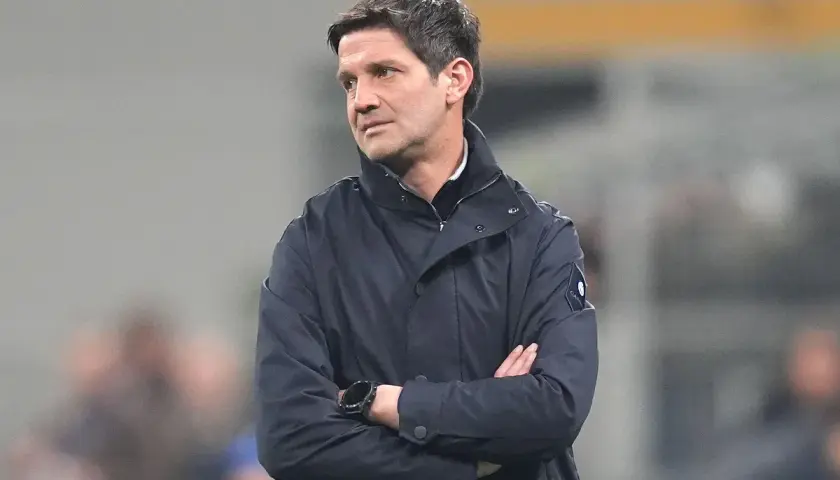 Trener Interu, Simone Inzaghi, w ciemnej kurtce, z rękami skrzyżowanymi na piersi, patrzy w bok.