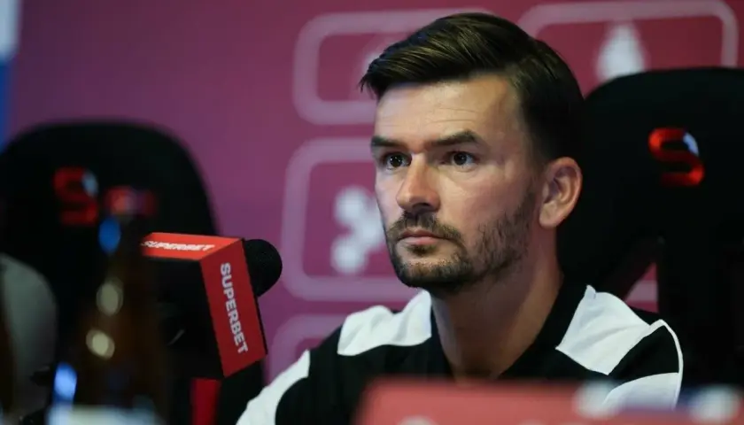 Trener Górnika Zabrze, w czarno-białej koszulce, siedzi przy mikrofonie Superbet.