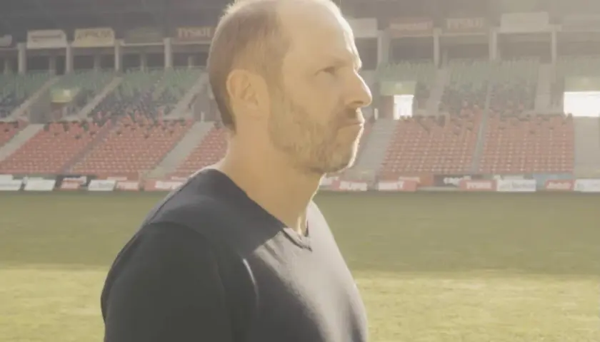 GKS Tychy trener wpatruje się w pusty stadion, gotowy na kolejne wyzwania.
