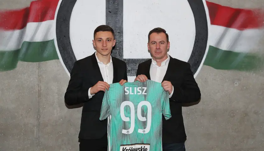 Dwóch mężczyzn prezentuje koszulkę z nazwiskiem SLISZ i numerem 99, symbolizującą rekord transferowy ekstraklasy.