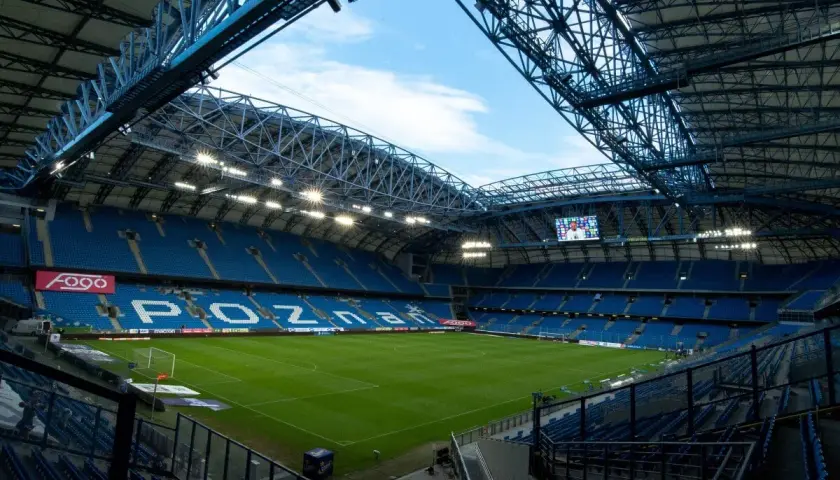 Pusta, błękitna arena z zieloną murawą i napisem "POZNAŃ" na trybunach. Pojemność stadionu Lecha Poznań robi wrażenie.