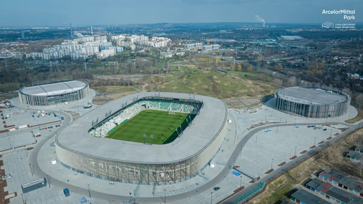 Nowoczesny stadion w Sosnowcu, ArcelorMittal Park, z zieloną murawą i trybunami. Jego pojemność pozwala na przyjęcie wielu kibiców.