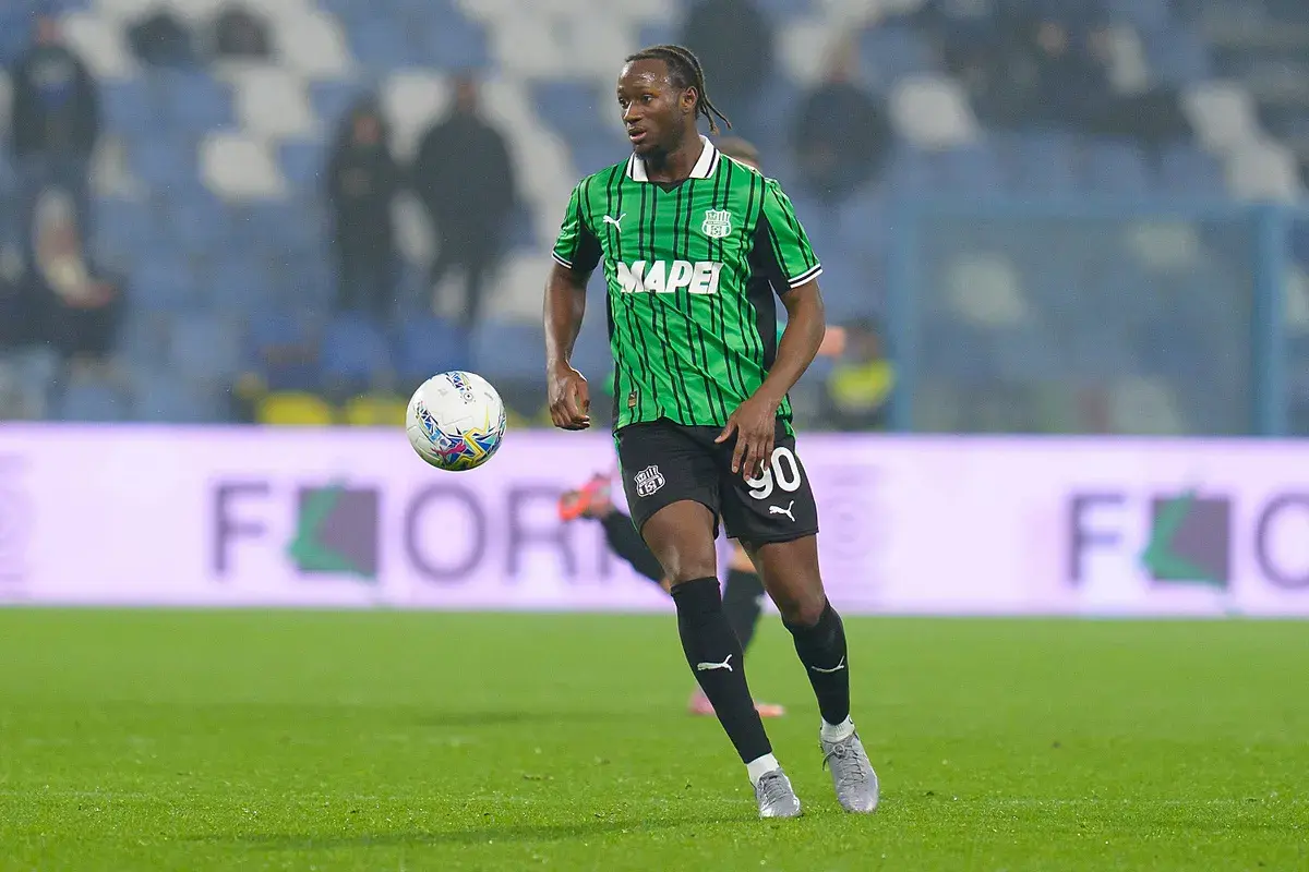 Piłkarz Sassuolo w zielono-czarnej koszulce z numerem 90 biegnie z piłką.