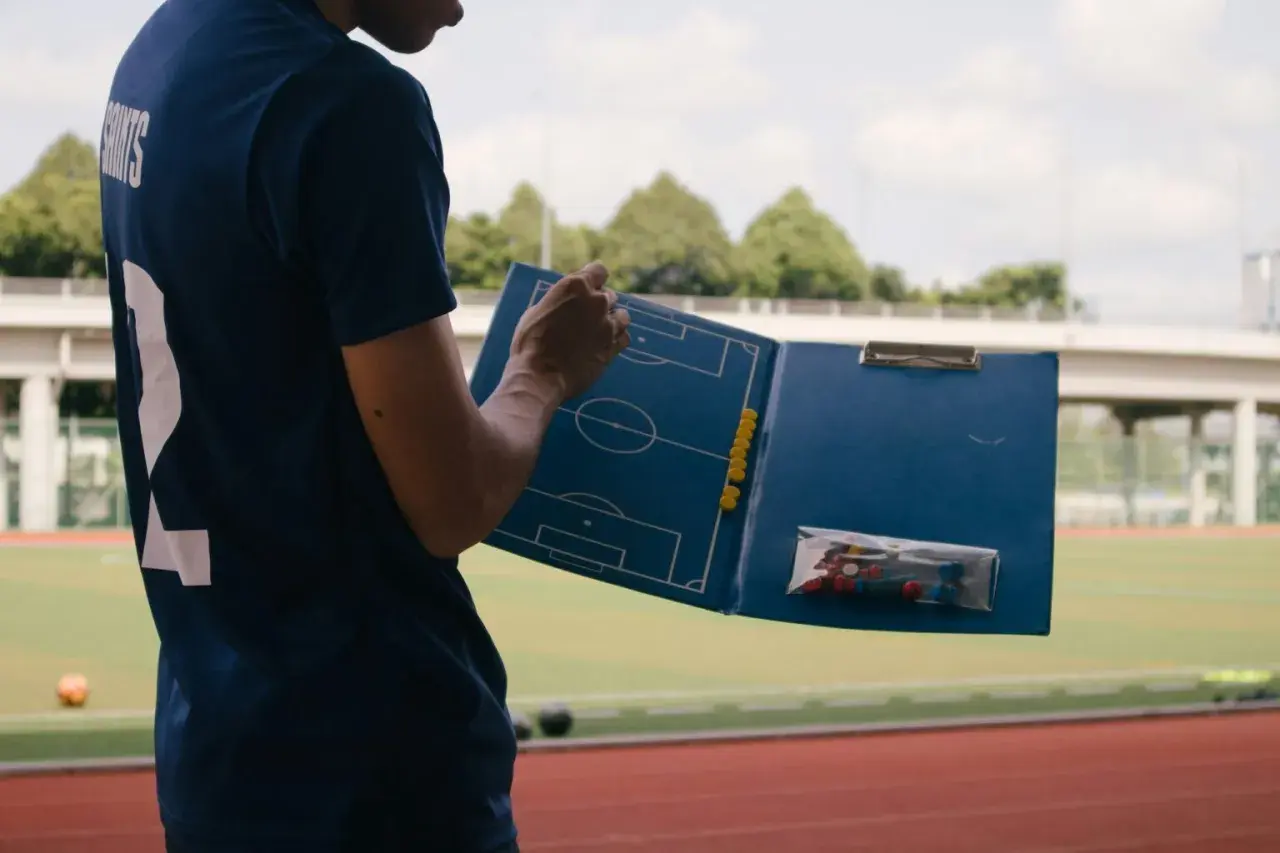 Trener analizuje taktykę na boisku, planując, co można trenować na kursie UEFA B.