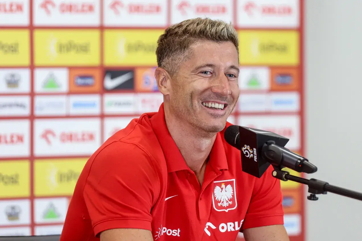 Uśmiechnięty Robert Lewandowski w czerwonej koszulce z orłem. Ciekawe, ile języków zna Robert Lewandowski, by dogadać się z fanami z całego świata.