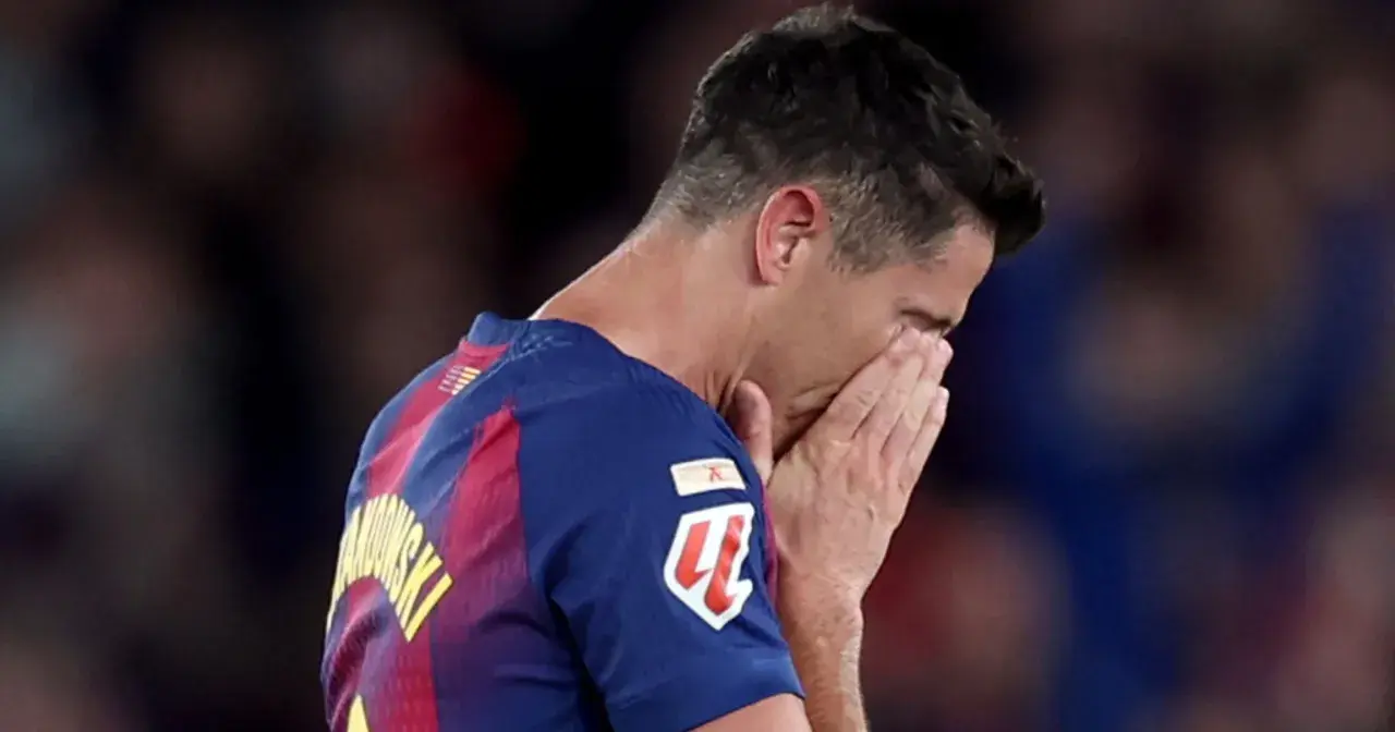 Piłkarz Robert Lewandowski z twarzą ukrytą w dłoniach, smutny po przegranym meczu, być może symbolizującym koniec kariery.