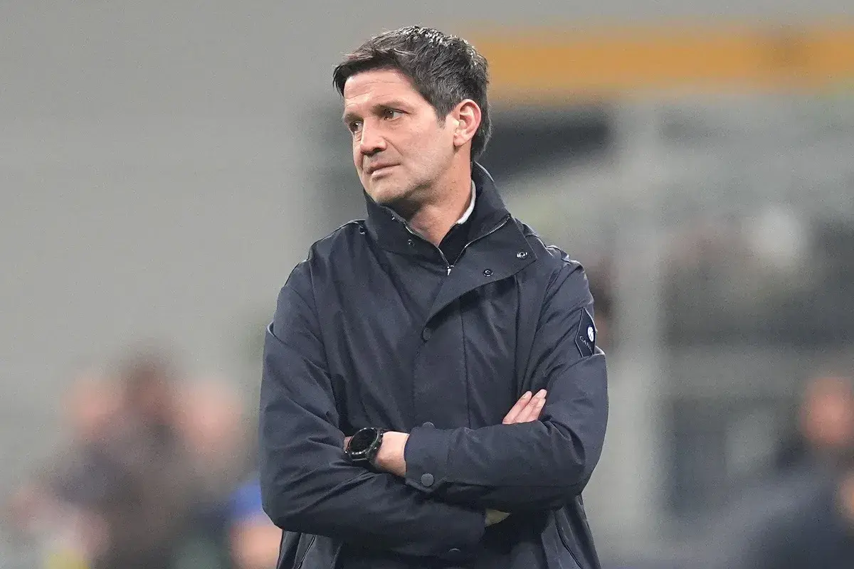Trener Interu, Simone Inzaghi, w ciemnej kurtce, z rękami skrzyżowanymi na piersi, patrzy w bok.