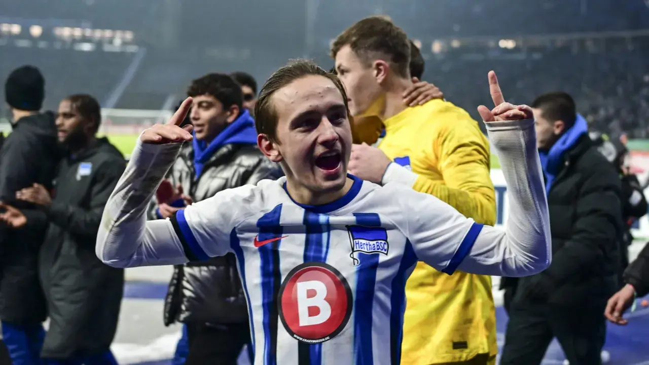 Radość zawodników Herthy BSC po zwycięstwie w 2. Bundeslidze. Młody piłkarz z uniesionymi rękami świętuje sukces.