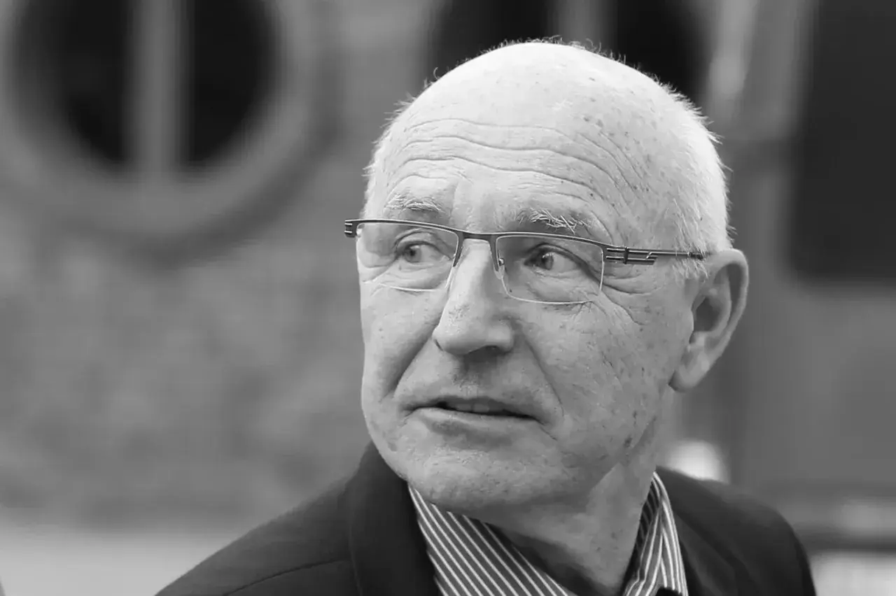 Portret starszego mężczyzny w okularach, który wygląda jak doświadczony lenczyk trener piłkarski, zamyślony.